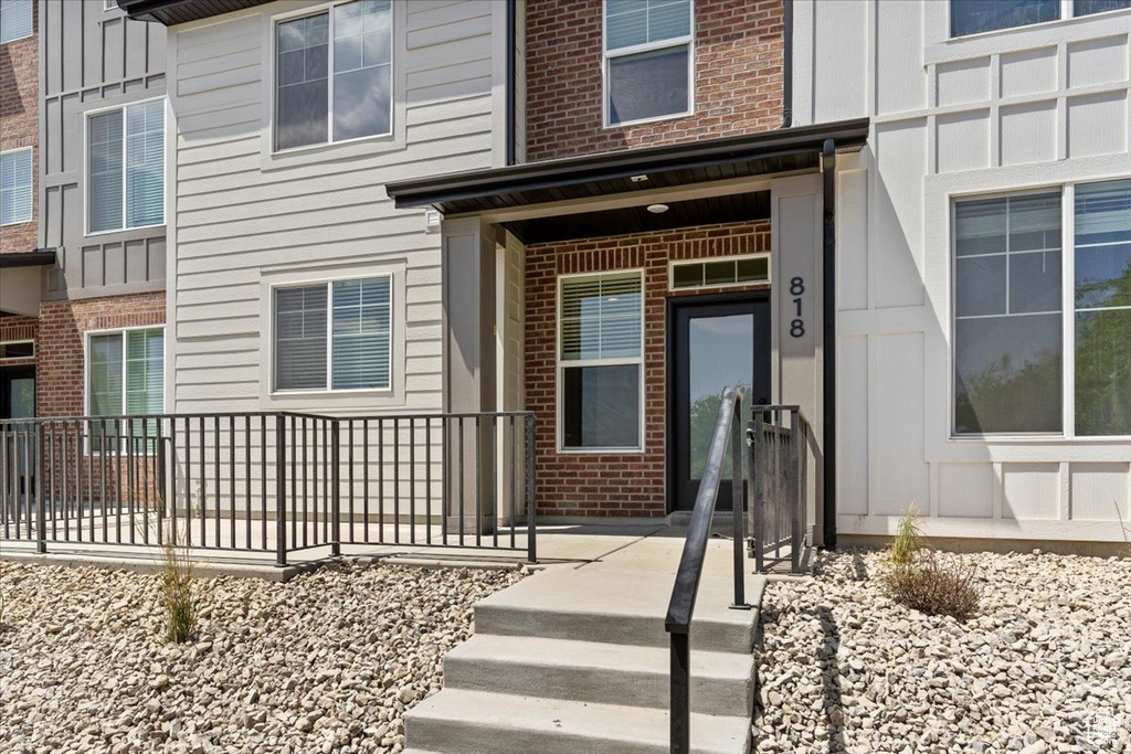 Entrance to property featuring brick siding and board and batten siding