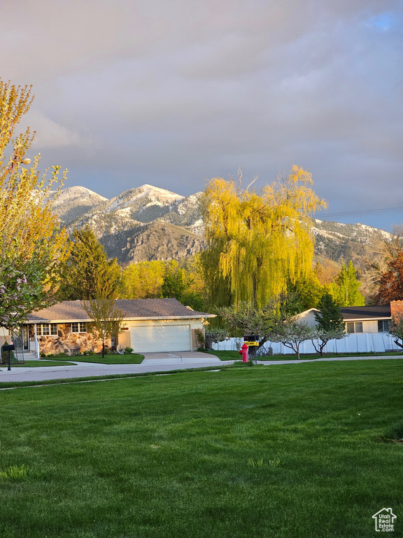 Surrounding community featuring a yard, a mountain view, and a garage