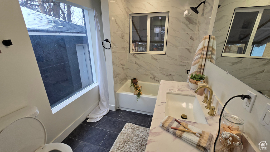 Bathroom with baseboards, shower / tub combo with curtain, vanity, and toilet