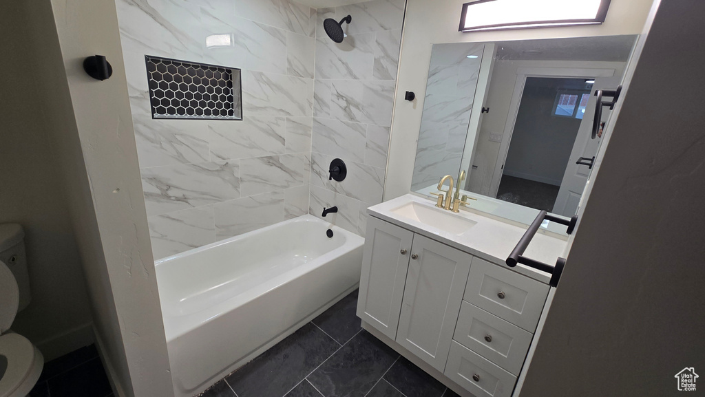 Bathroom featuring shower / bath combination, vanity, and toilet