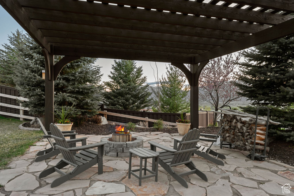 View of patio with fence, a pergola, and a fire pit