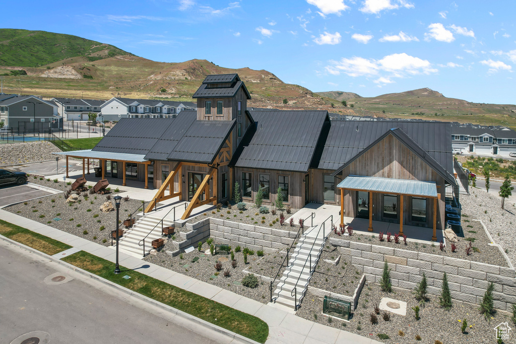 View of front of house with stairs, metal roof, a standing seam roof, and a mountain view