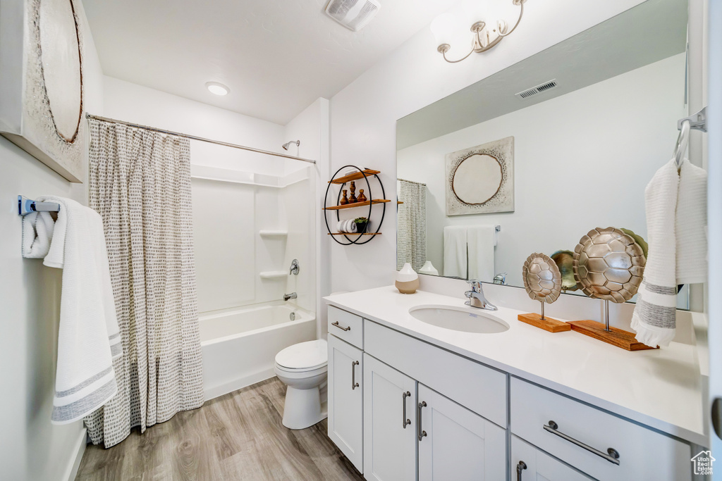 Bathroom with toilet, visible vents, wood finished floors, and vanity