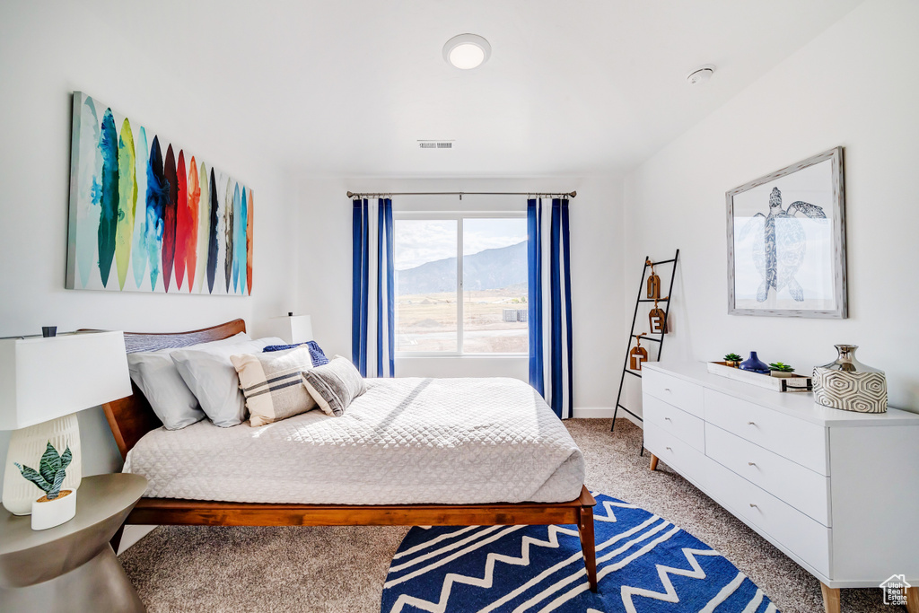 Bedroom featuring baseboards, a mountain view, and light colored carpet