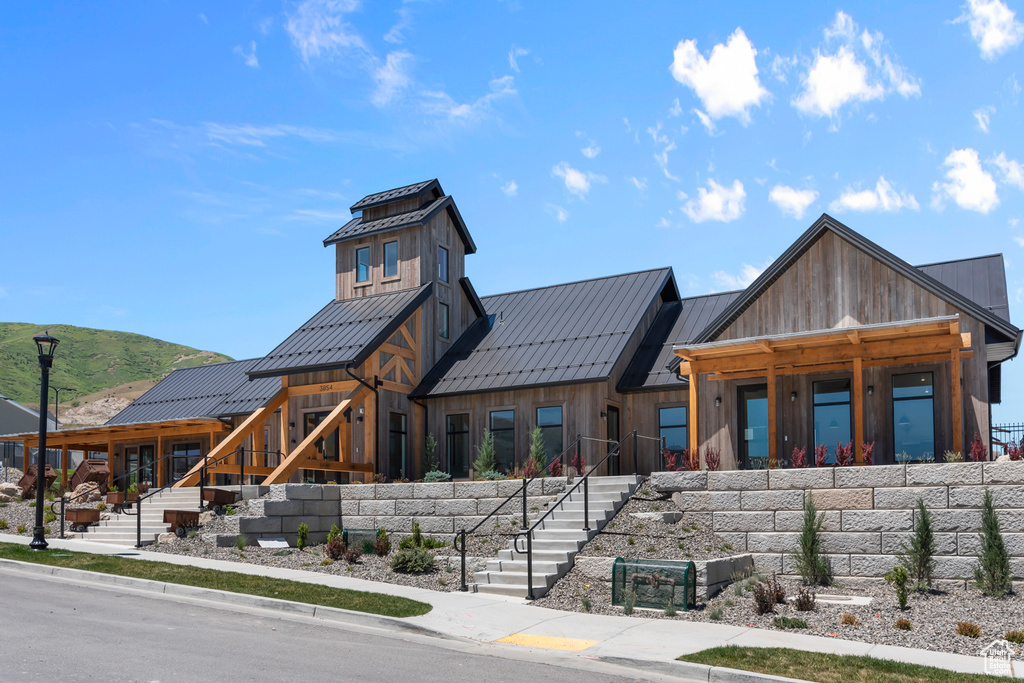 View of front facade with metal roof, a standing seam roof, and board and batten siding