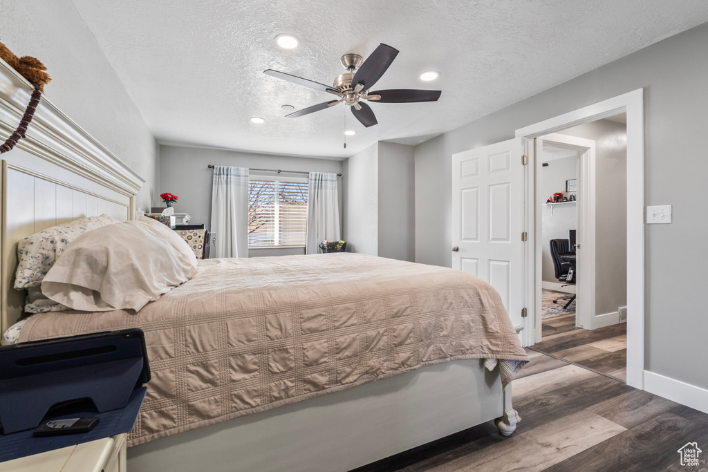 Bedroom with wood finished floors, baseboards, recessed lighting, a textured ceiling, and ceiling fan
