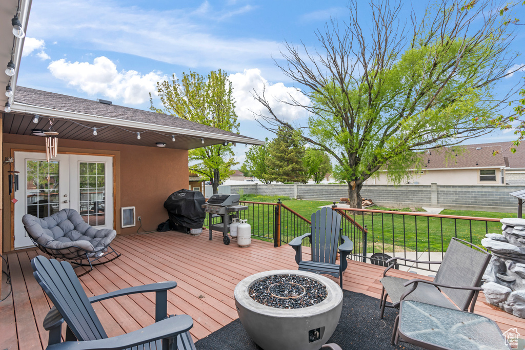Wooden deck with a fire pit, a grill, and french doors