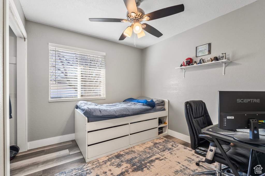 Bedroom featuring a desk, wood finished floors, and baseboards