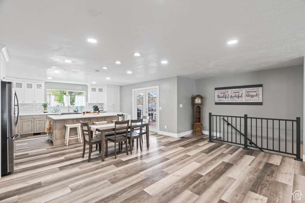 Dining room featuring recessed lighting, light wood finished floors, baseboards, and french doors