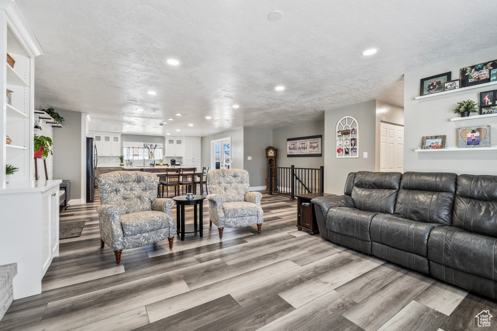 Living area with light wood-type flooring, recessed lighting, and baseboards