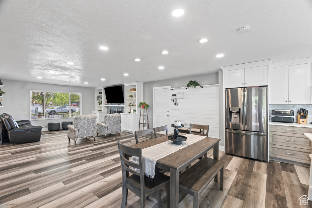 Dining space with recessed lighting, wood finished floors, and a textured ceiling
