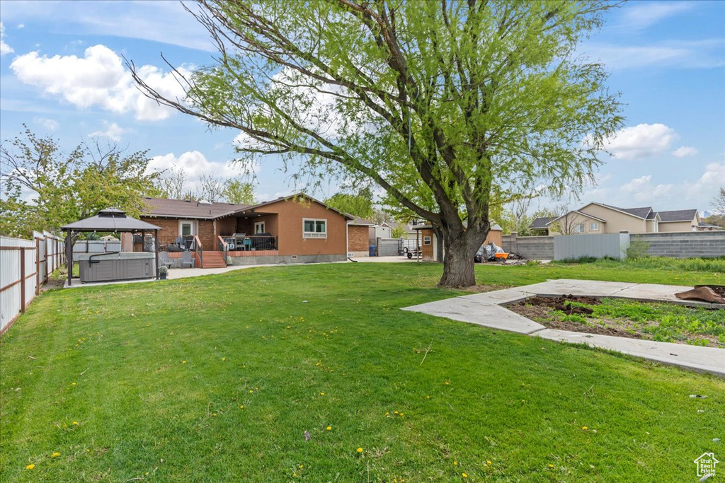 View of yard with a hot tub and a gazebo