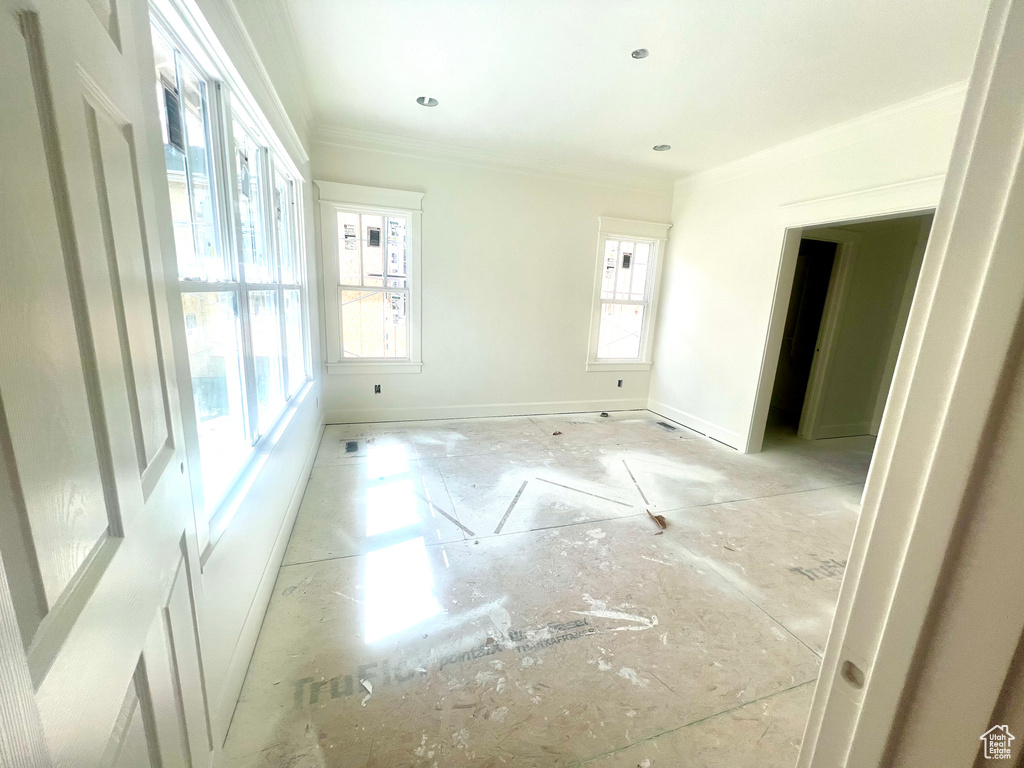 Empty room with crown molding and baseboards