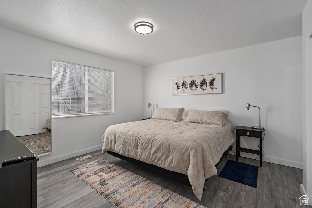 Bedroom featuring wood finished floors, visible vents, and baseboards