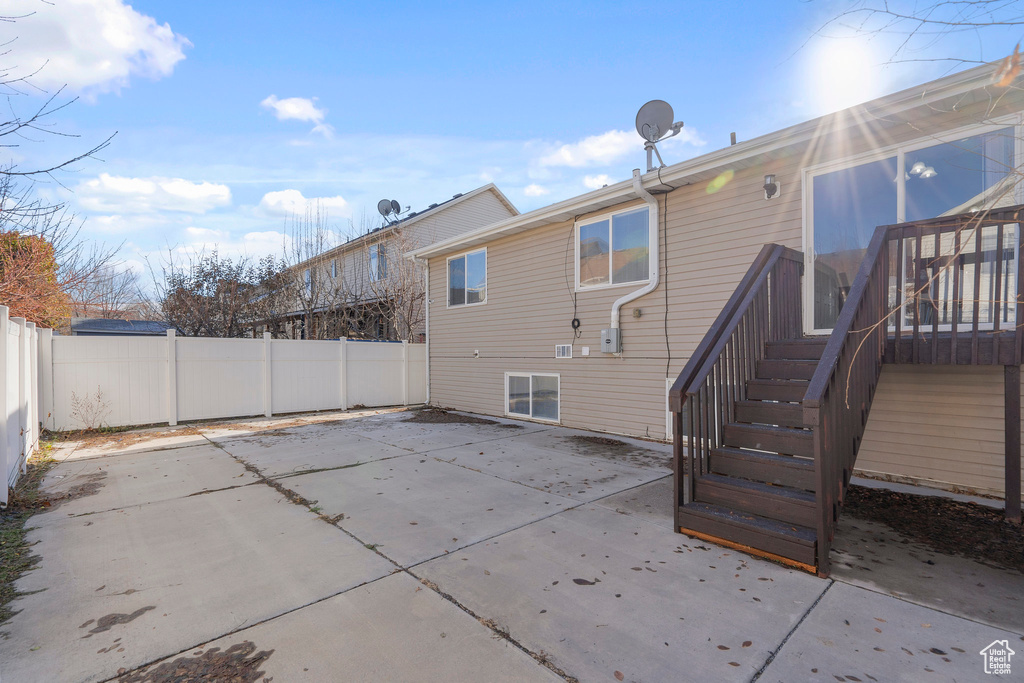 Back of property featuring a patio area, a fenced backyard, and stairway
