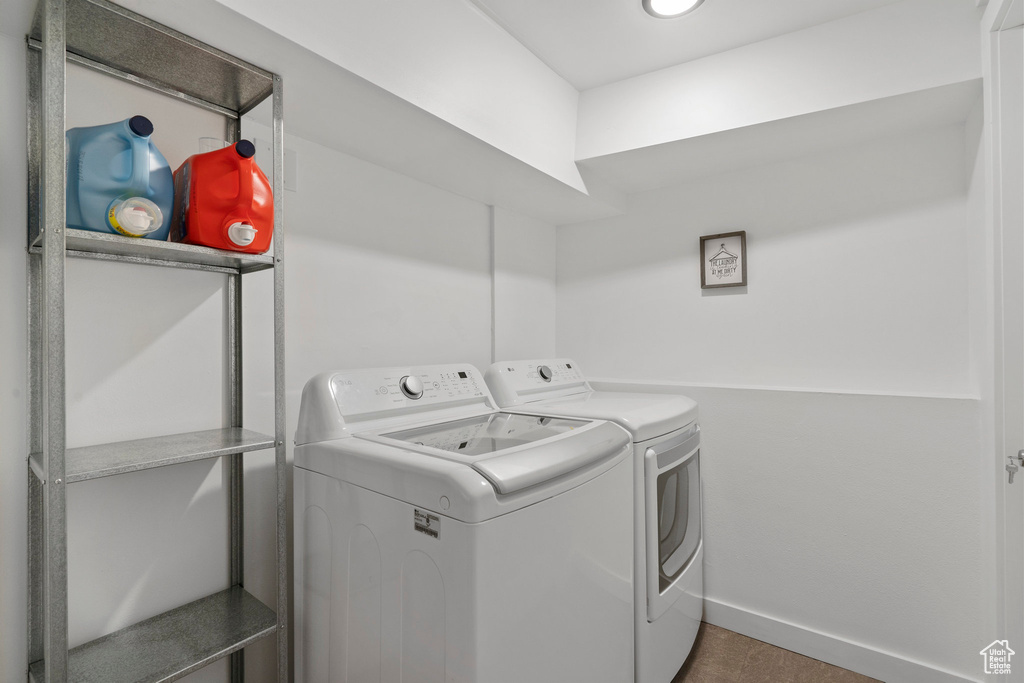Clothes washing area featuring laundry area, baseboards, and washer and clothes dryer