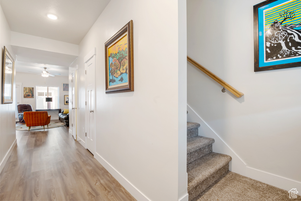 Corridor featuring light wood-type flooring, baseboards, and stairway