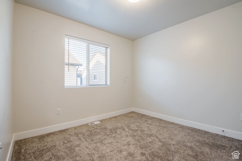 Spare room with carpet flooring, visible vents, and baseboards