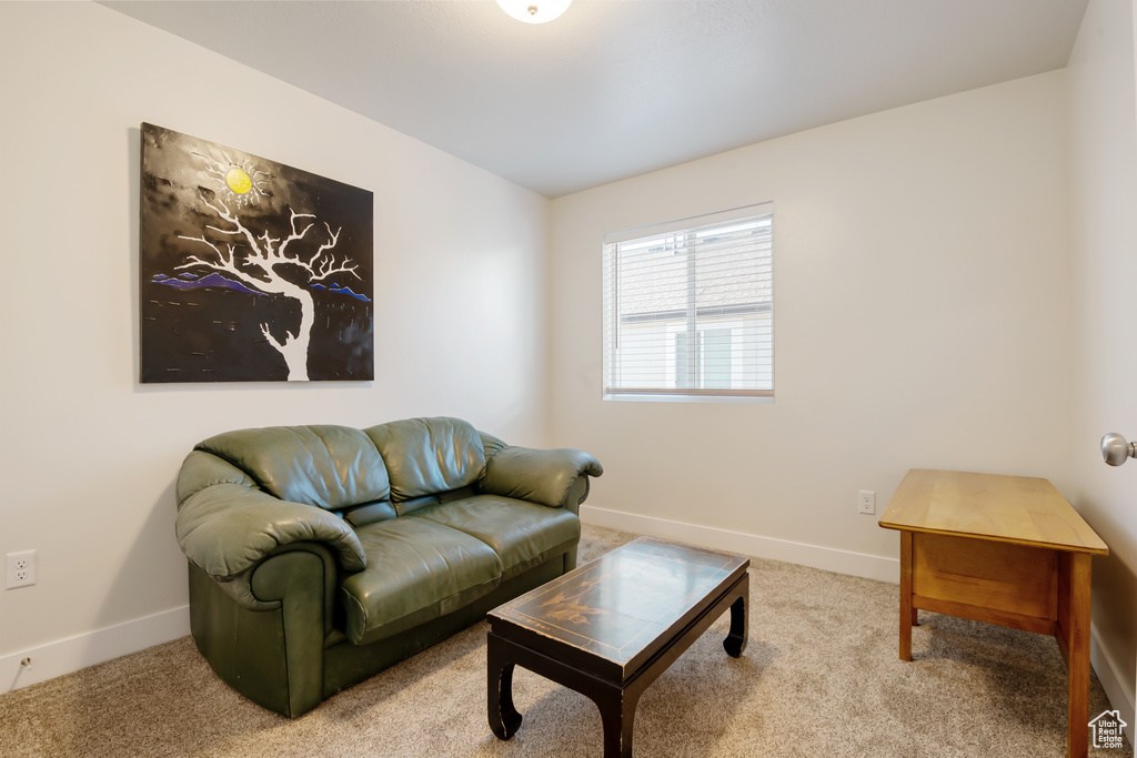 Carpeted living area featuring baseboards