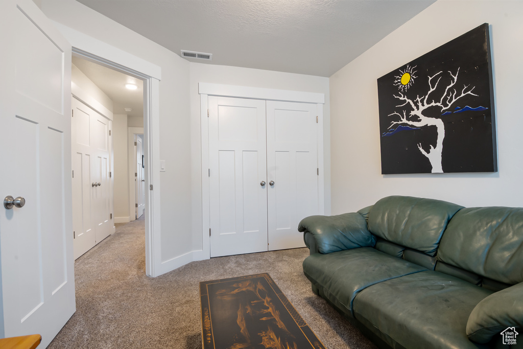 Carpeted living room featuring visible vents and baseboards