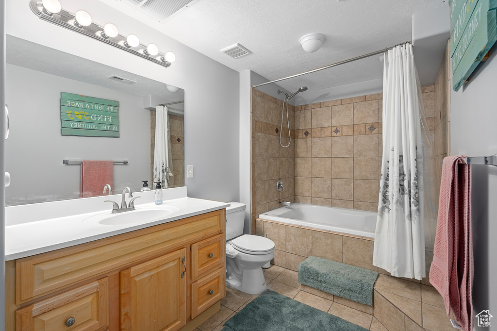 Bathroom featuring visible vents, tiled shower / bath combo, toilet, and tile patterned floors