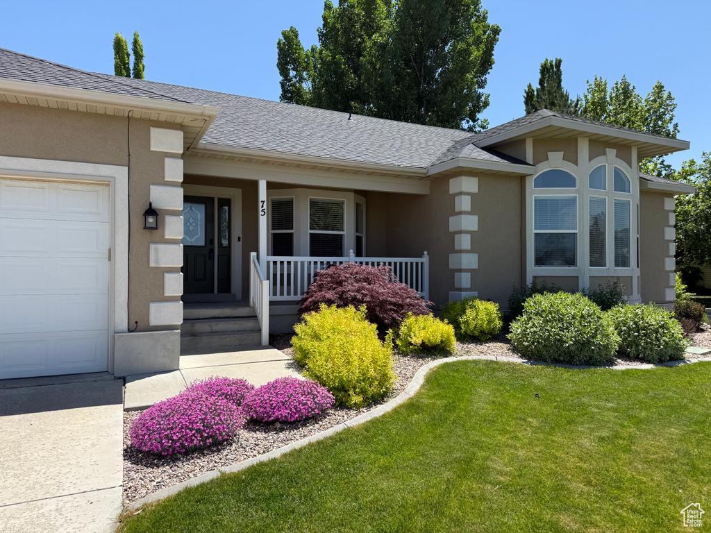 View of front of house featuring stucco siding, a porch, a garage, and a shingled roof