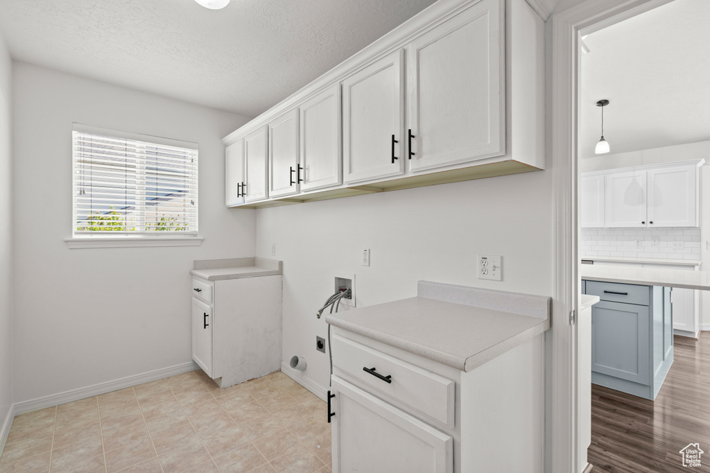 Laundry area with washer hookup, cabinet space, baseboards, hookup for an electric dryer, and a textured ceiling