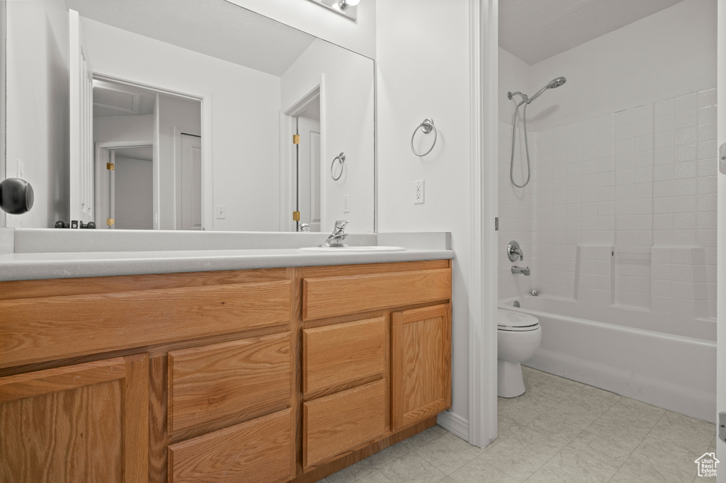 Bathroom with vanity, bathtub / shower combination, toilet, and tile patterned floors