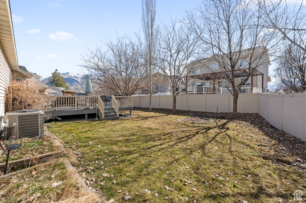 View of yard featuring a fenced backyard, central AC unit, and a wooden deck