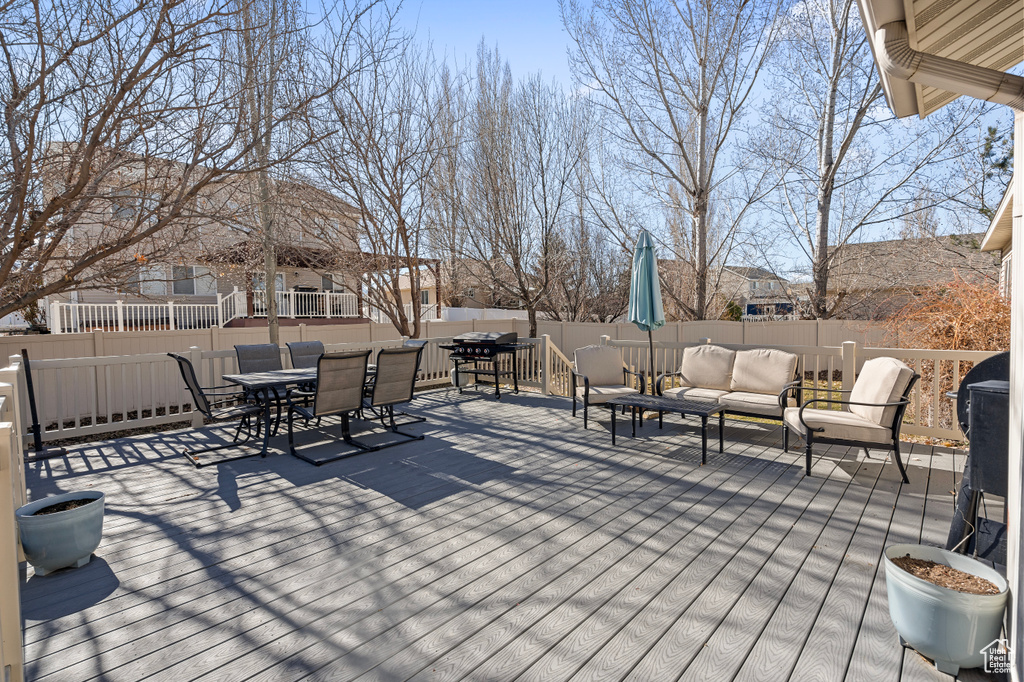 Wooden terrace featuring outdoor dining space, outdoor lounge area, and a fenced backyard