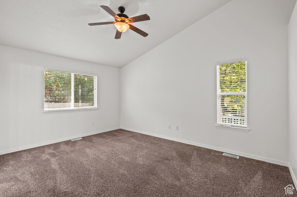 Unfurnished room featuring lofted ceiling, carpet flooring, ceiling fan, and baseboards