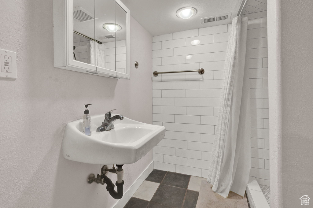 Bathroom with a shower stall, visible vents, and tile patterned flooring