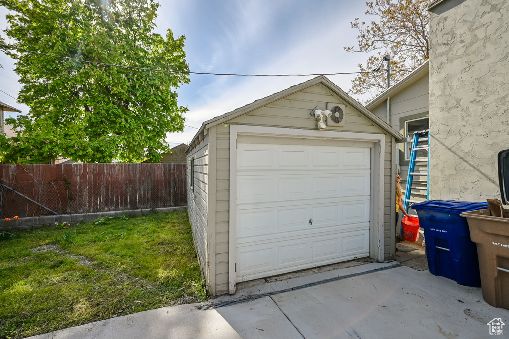 Detached garage featuring fence and concrete driveway