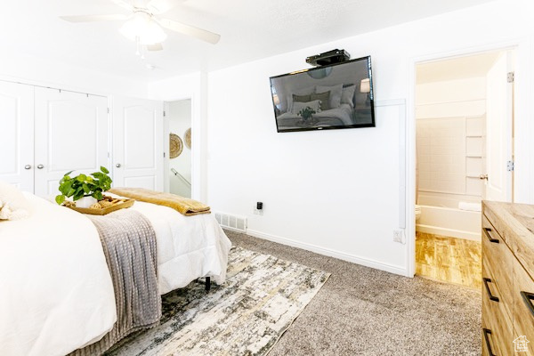 Bedroom featuring light colored carpet, visible vents, ensuite bathroom, a ceiling fan, and baseboards