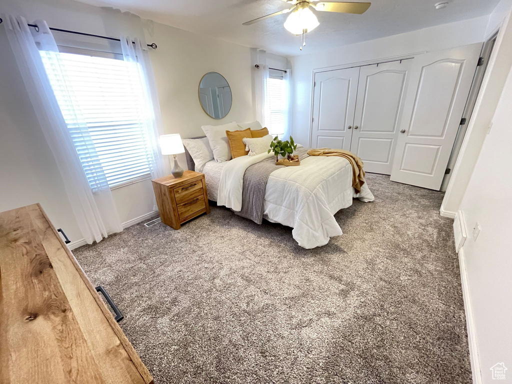 Bedroom featuring carpet floors, baseboards, a ceiling fan, and a closet