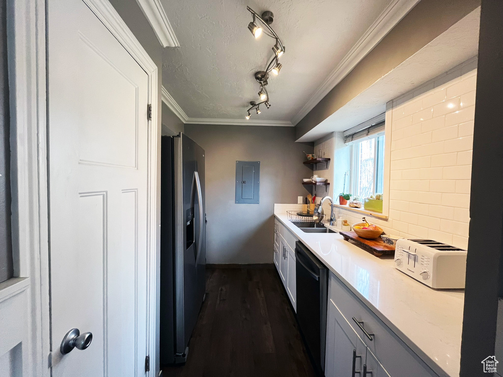 Kitchen featuring stainless steel refrigerator with ice dispenser, dishwasher, a sink, track lighting, and dark wood finished floors