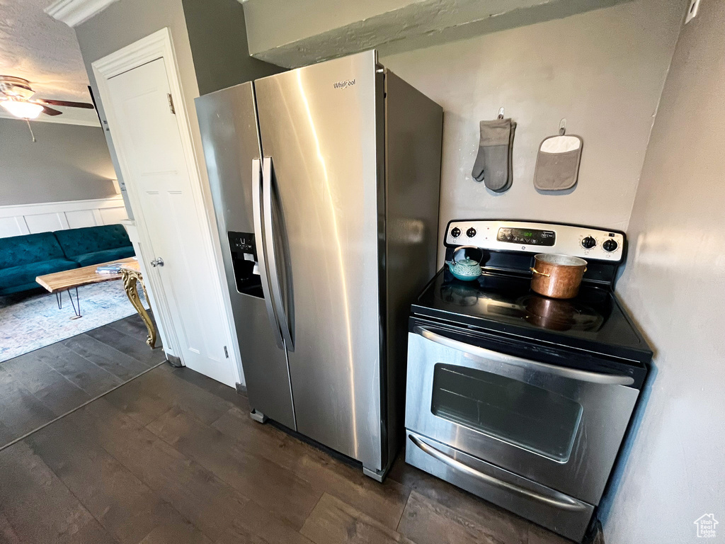 Kitchen with appliances with stainless steel finishes, dark wood-style floors, ceiling fan, and a textured ceiling