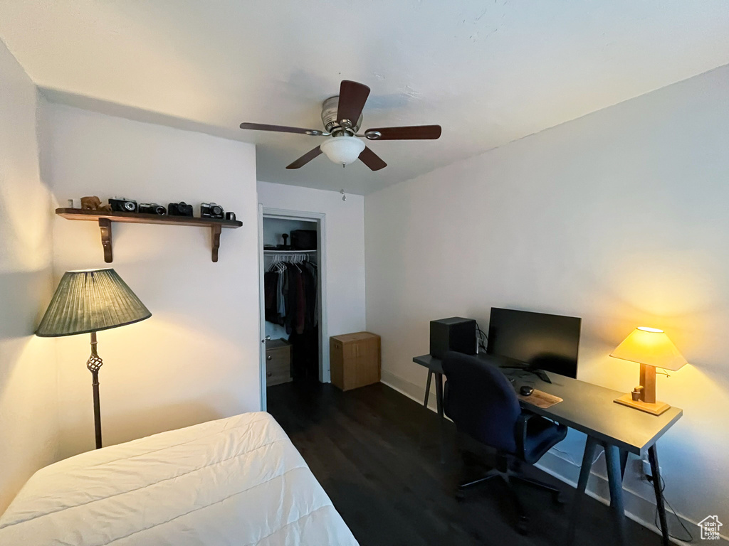Bedroom with wood finished floors, a closet, a desk, and ceiling fan