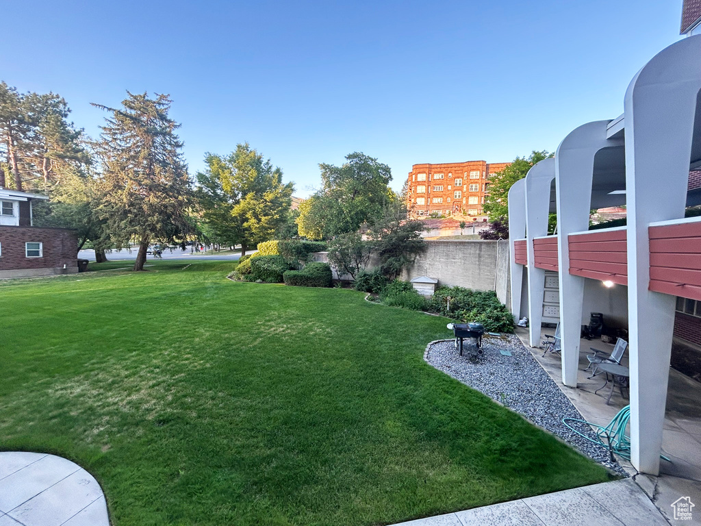 View of grassy yard with a patio area