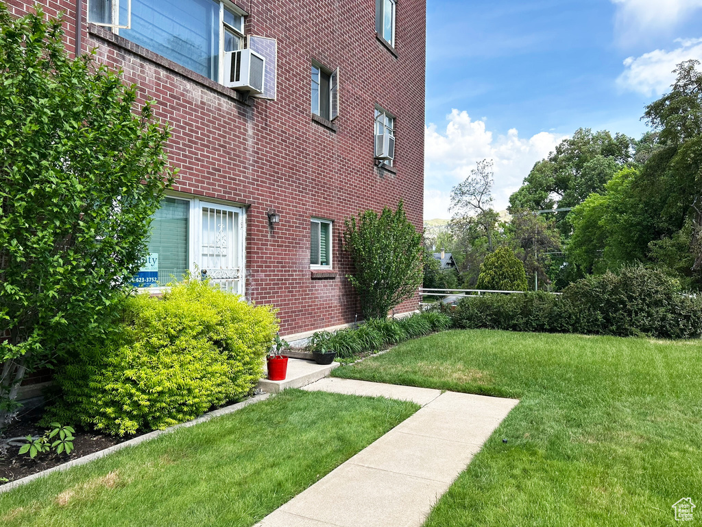 View of grassy yard with cooling unit