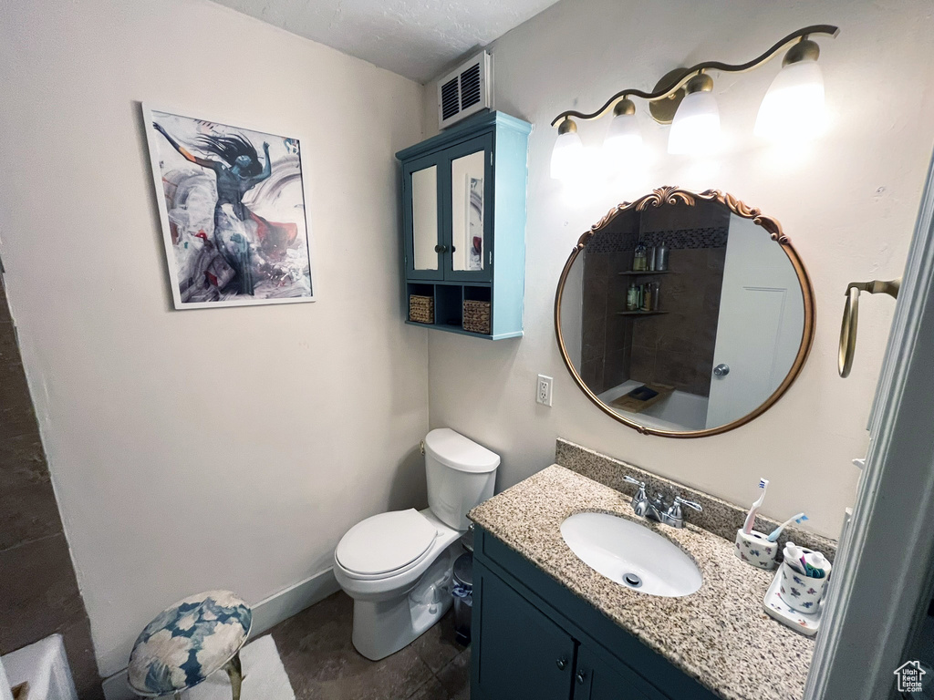 Bathroom featuring vanity, toilet, and baseboards