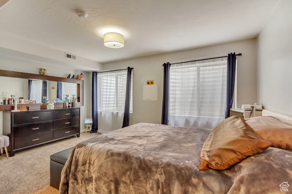 Bedroom with light carpet and visible vents