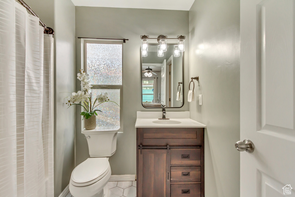 Bathroom with toilet, a shower with curtain, baseboards, and vanity
