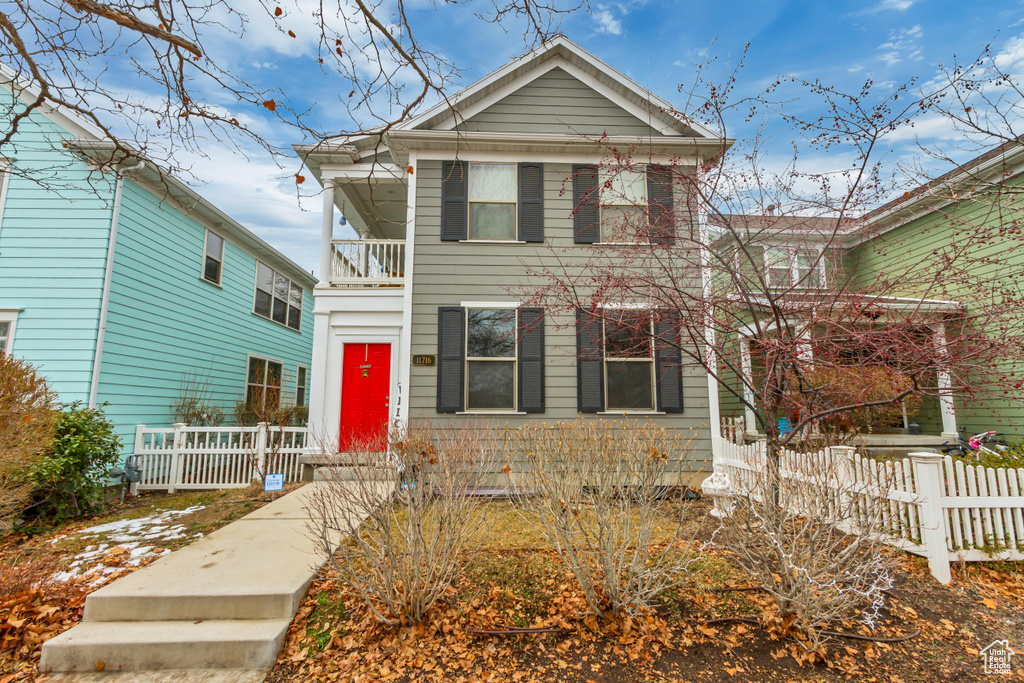 View of front of home with a balcony and fence