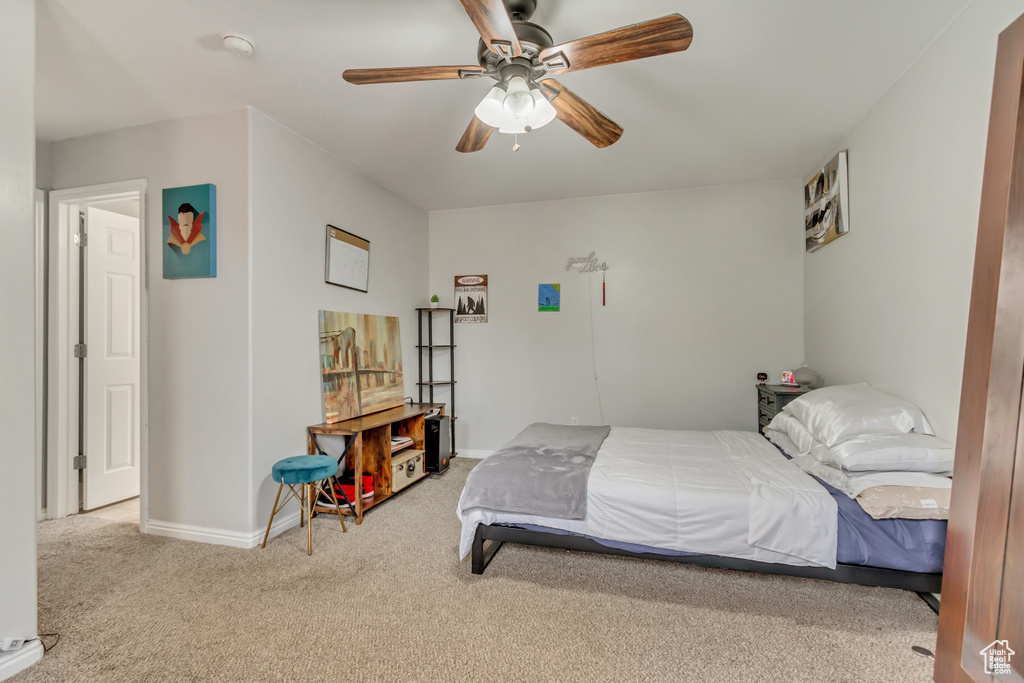 Carpeted bedroom with ceiling fan and baseboards