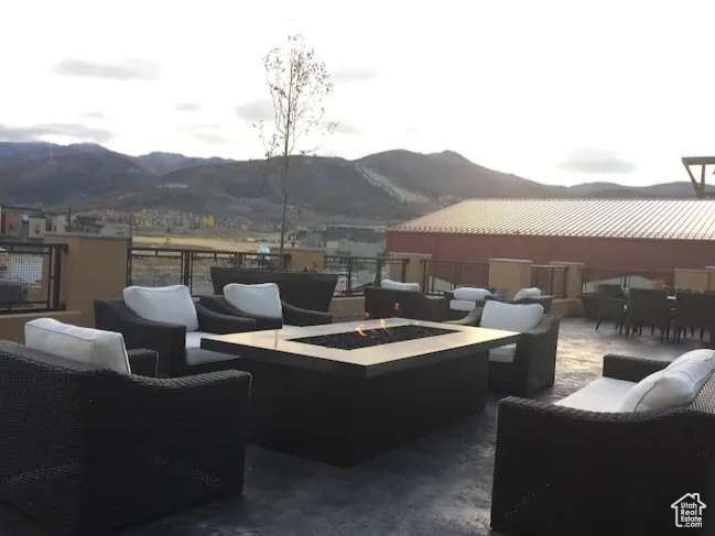 View of patio with outdoor dining space, a mountain view, and an outdoor living space with a fire pit