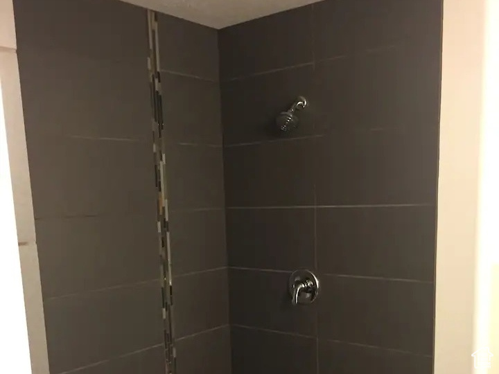 Full bath featuring a stall shower and a textured ceiling