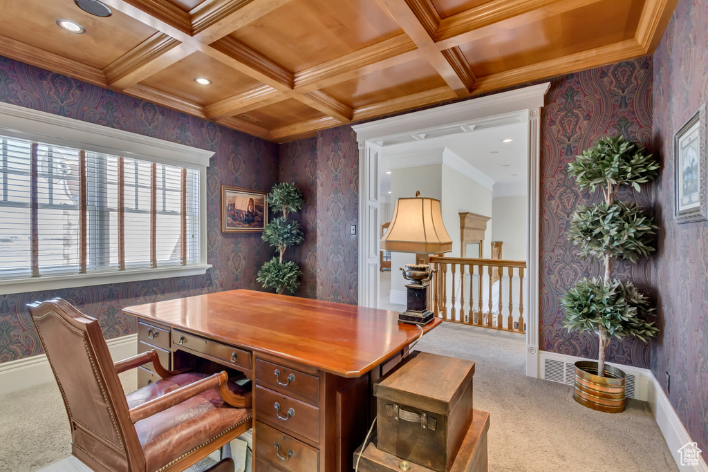 Carpeted home office featuring baseboards, crown molding, coffered ceiling, and wallpapered walls