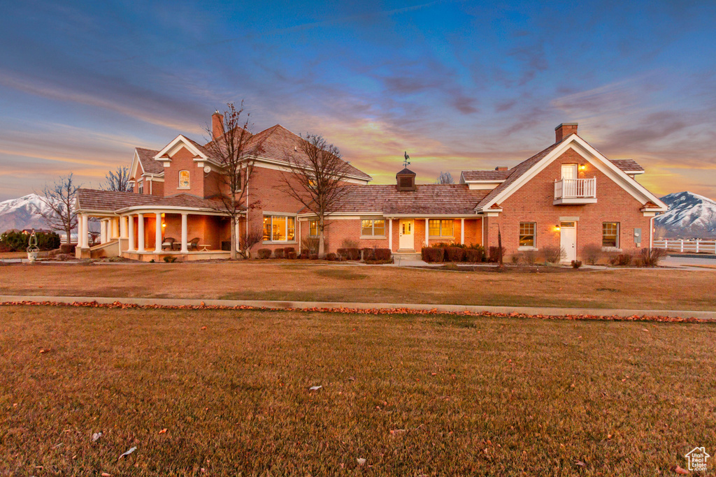 Traditional-style house featuring brick siding, a chimney, and a yard