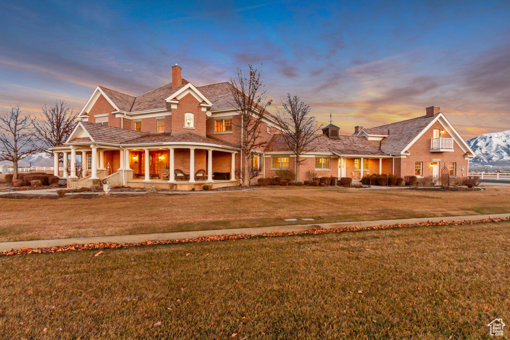 View of front of property featuring a chimney, a front lawn, and brick siding